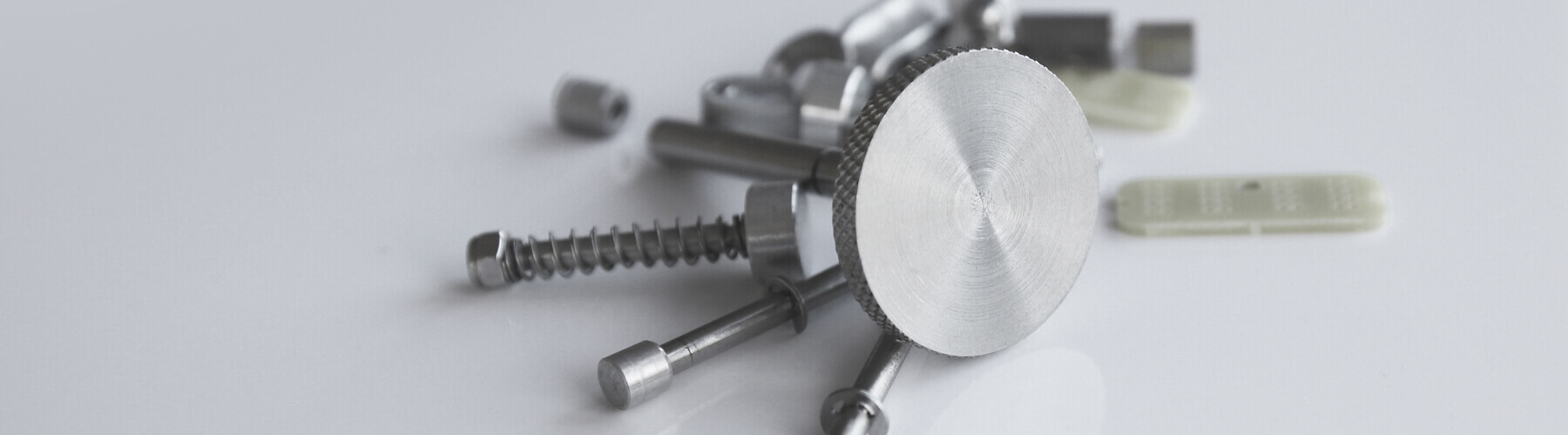 Auf einer weißen Oberfläche liegen verschiedene Formteile.